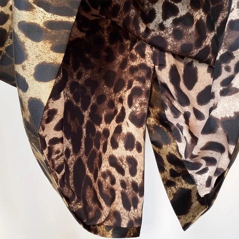Leopard print fabric in shades of brown and beige, featuring a silky texture and stylish drape. Perfect for fashion designs.