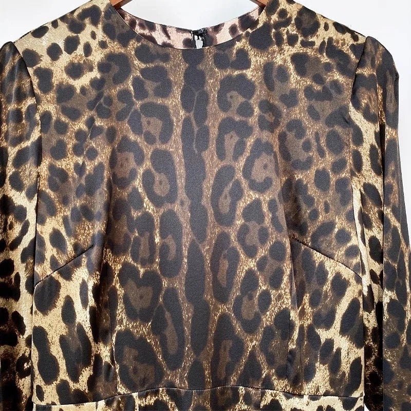 Leopard print blouse in brown and black satin with a modern silhouette and rounded neckline. Perfect for stylish layering.
