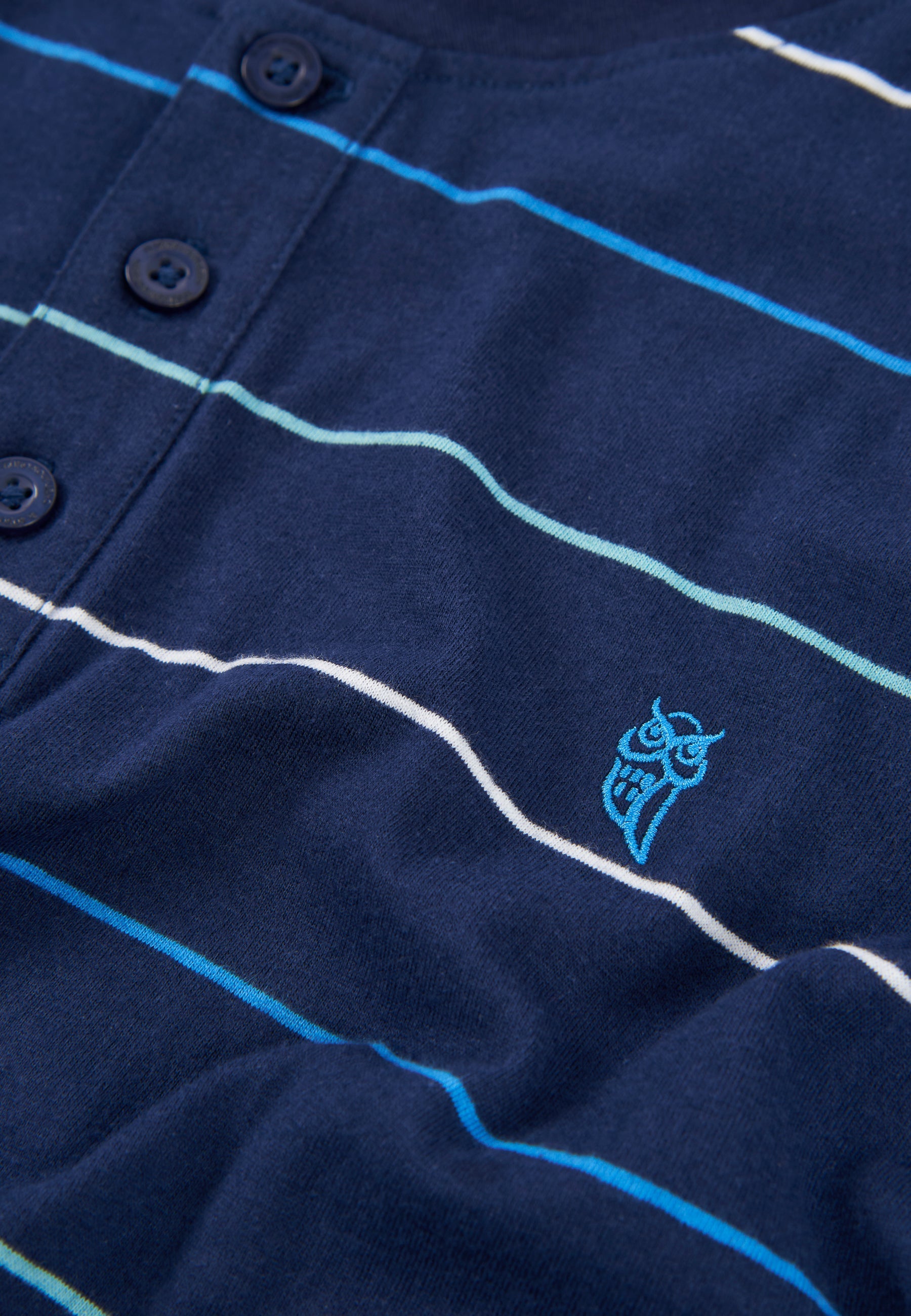 Camisa de rayas azul marino con botones y logo azul, de algodón suave y estilo casual.