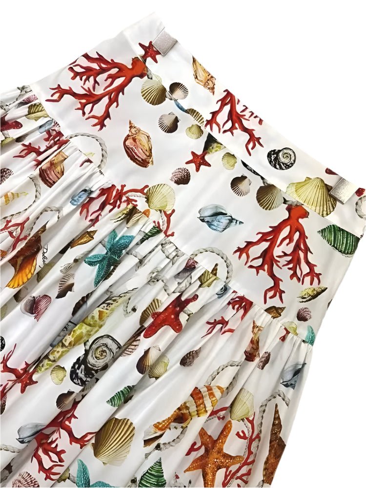 White cotton maxi skirt featuring a vibrant print of colorful seashells, starfish, coral, and rope patterns.
