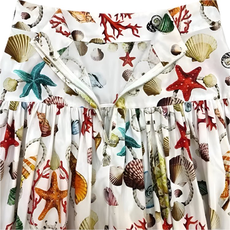 White cotton maxi skirt with colorful seashell, starfish, and coral print, featuring a zippered waistband.