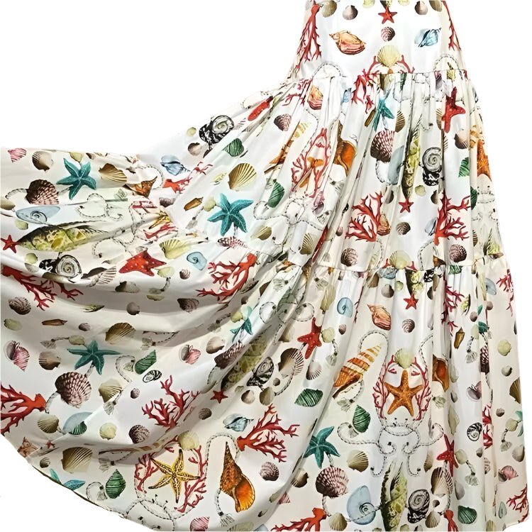 White cotton maxi skirt featuring a vibrant, colorful seashell and coral print with a tiered, flowing silhouette.