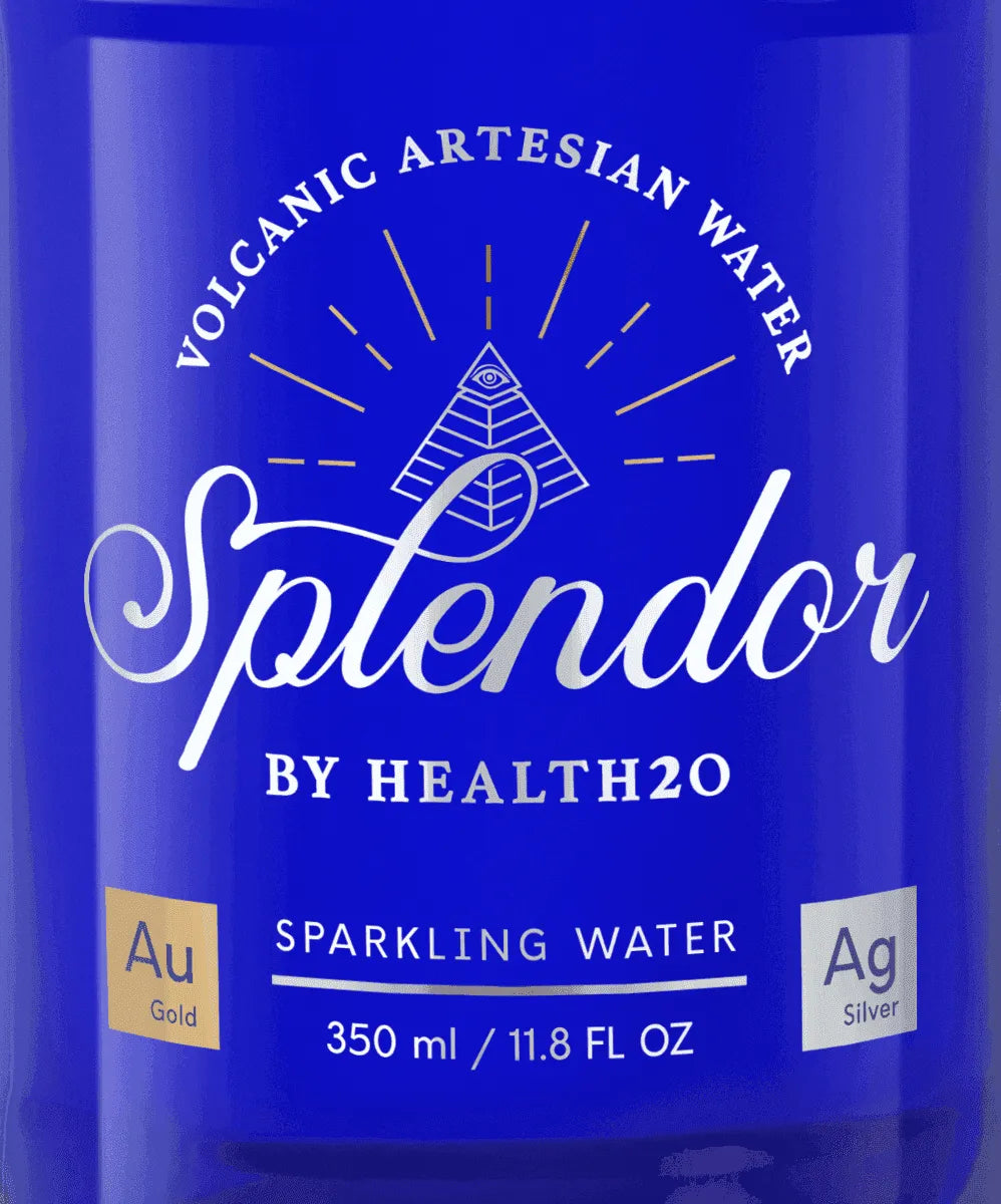Close-up of a blue glass bottle label featuring the white script logo "Splendor," a pyramid icon, and "350ML" text.
