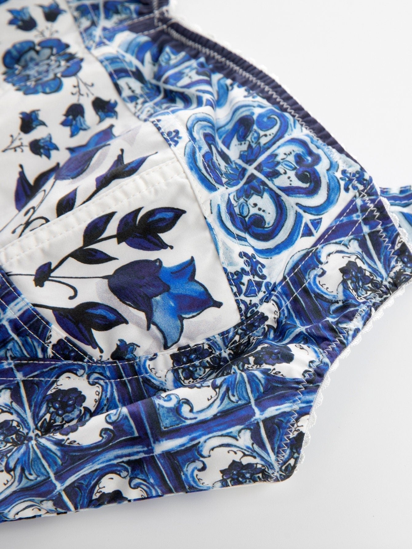 Cotton crop top with blue and white Italian Majolica tile and floral print, featuring stitched, structured cup panels.