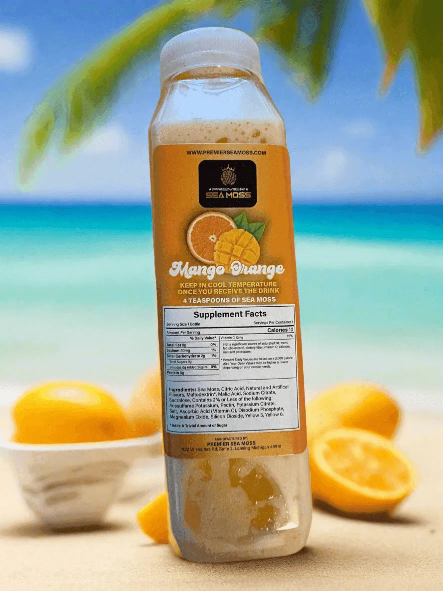 12 oz. Mango Orange Sea Moss drink in a clear plastic bottle with a nutritional label, on a tropical beach background.