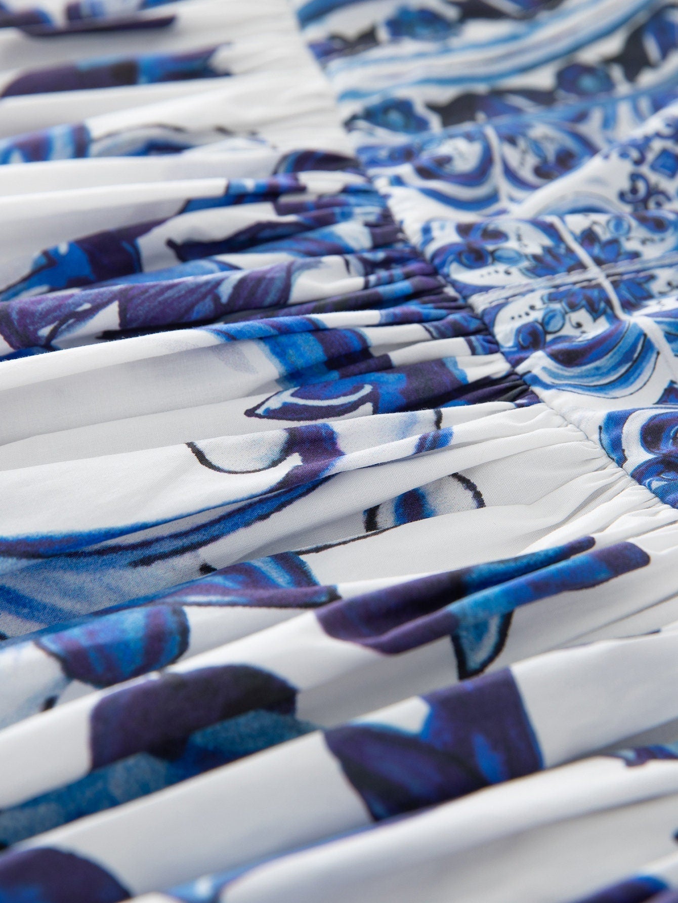 Blue and white floral print fabric with gathered detailing, perfect for summer dresses or stylish tops.