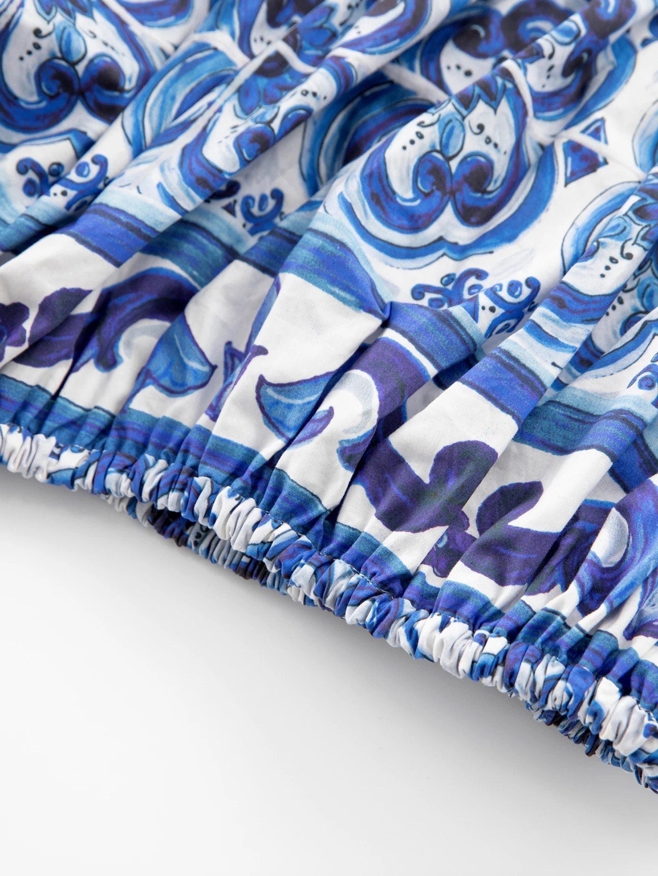 Blue and white floral-patterned pleated dress with elastic waistband in lightweight fabric. Perfect for summer outings.