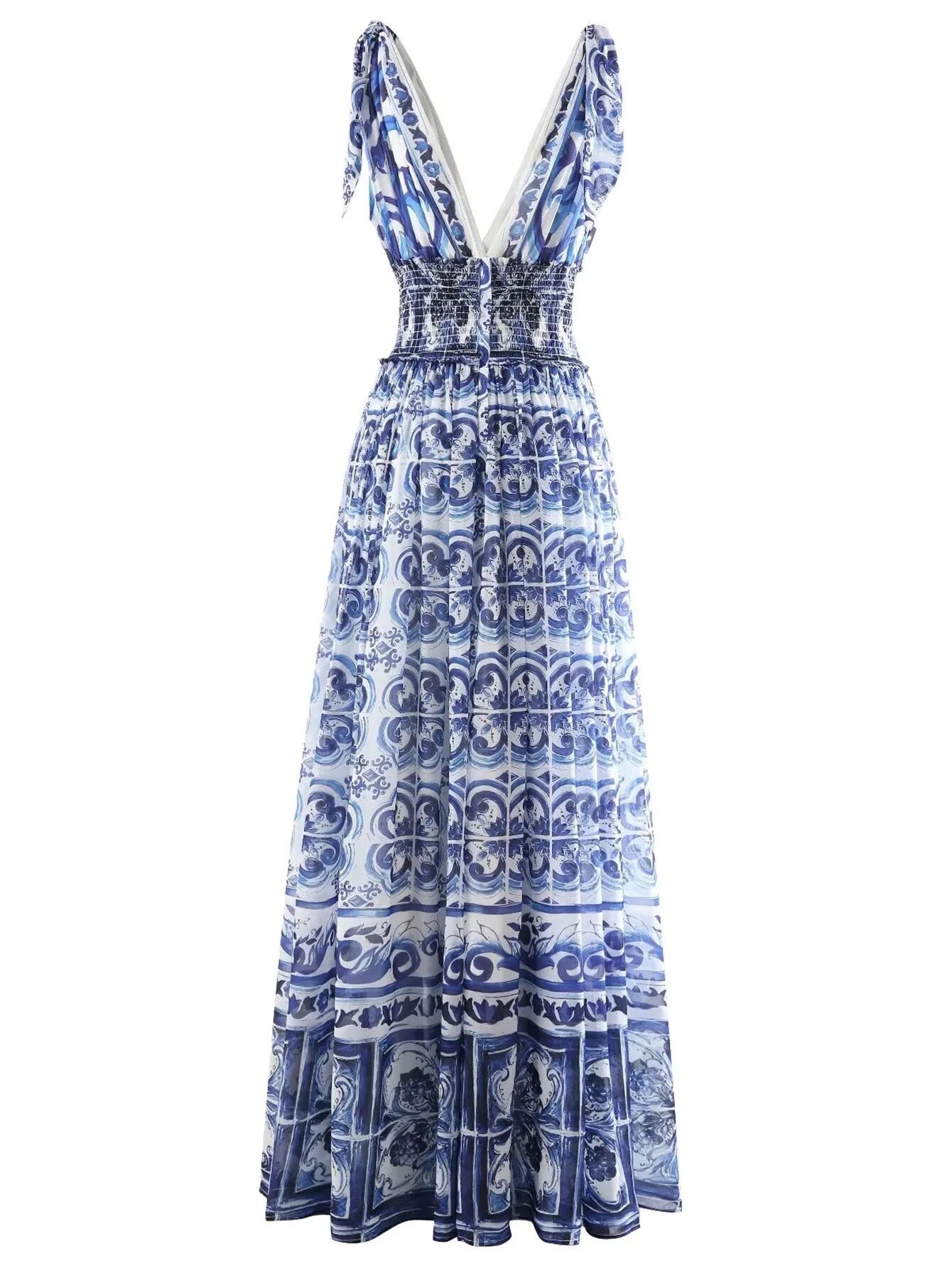 Blue and white patterned maxi dress with smocked bodice and ruffled straps, perfect for summer occasions.