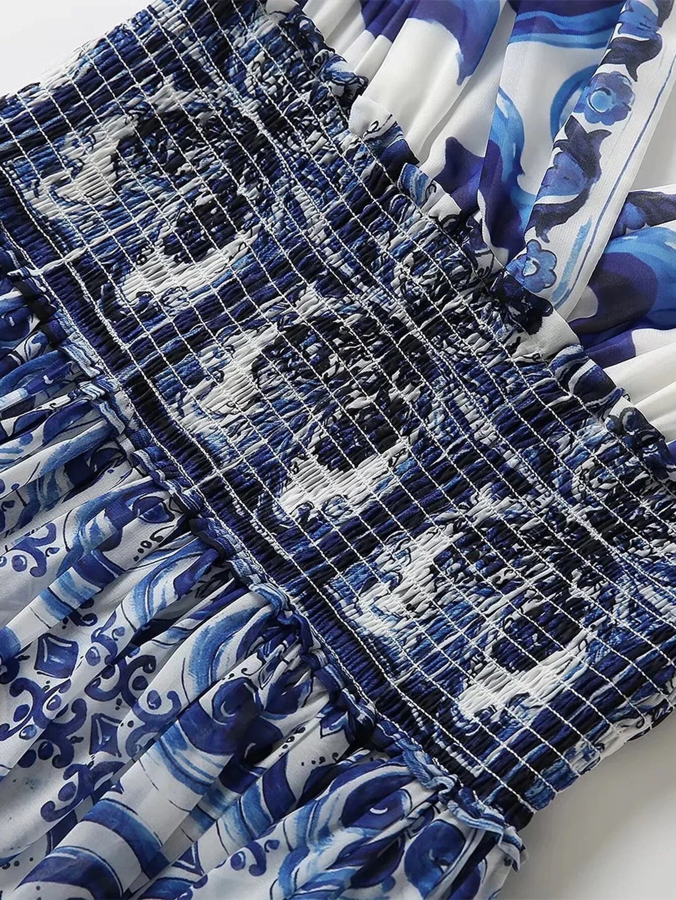 Blue and white floral patterned smocked dress with a feminine design, perfect for summer outings.