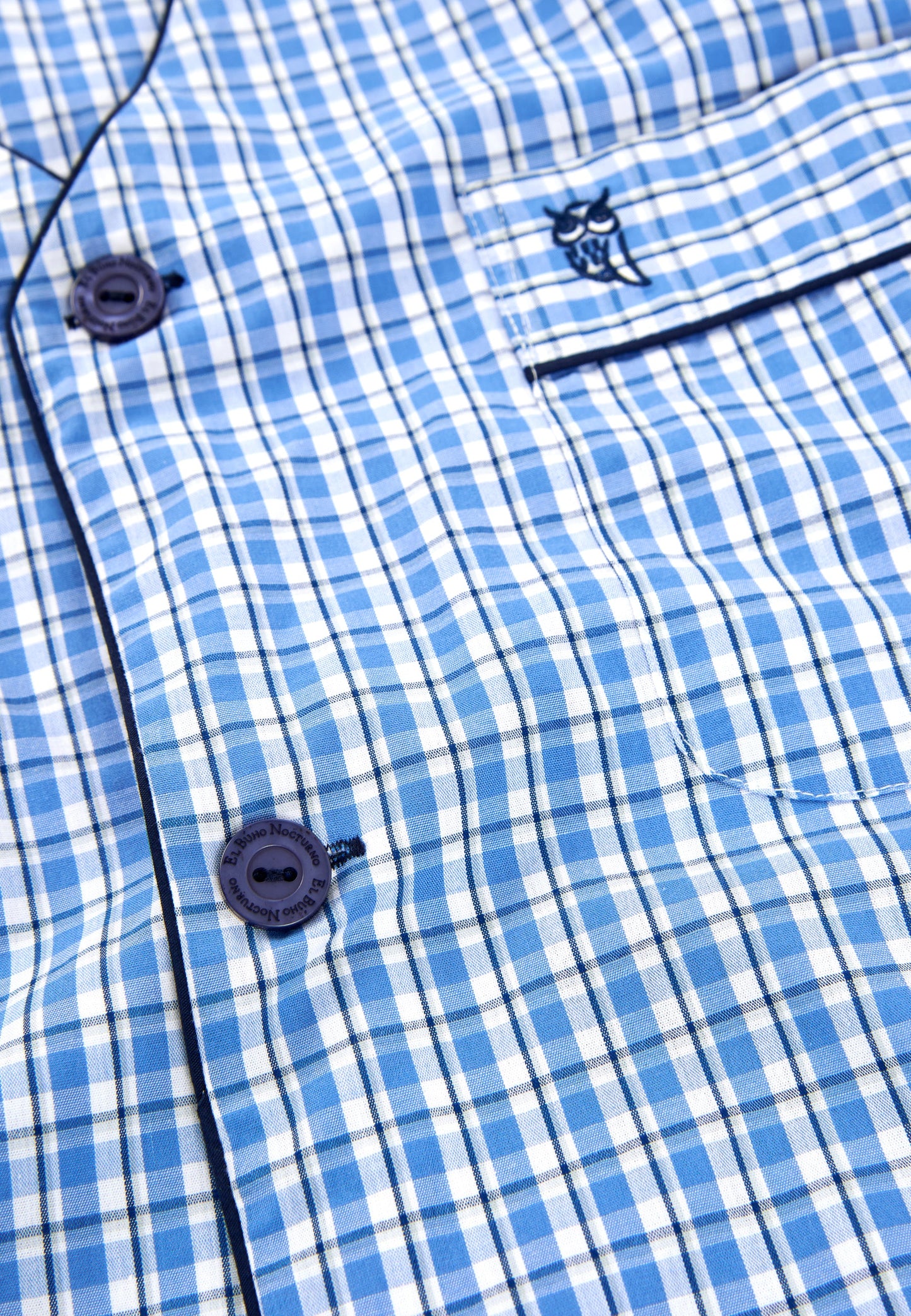 Camisa de cuadros azul, mezcla de algodón, estilo casual, con botones oscuros y bordado en el pecho.