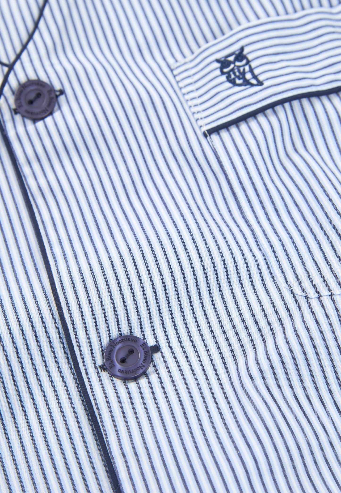 Camisa de algodón azul y blanca con rayas, botones oscuros y bolsillo con logo bordado. Ideal para un estilo casual.