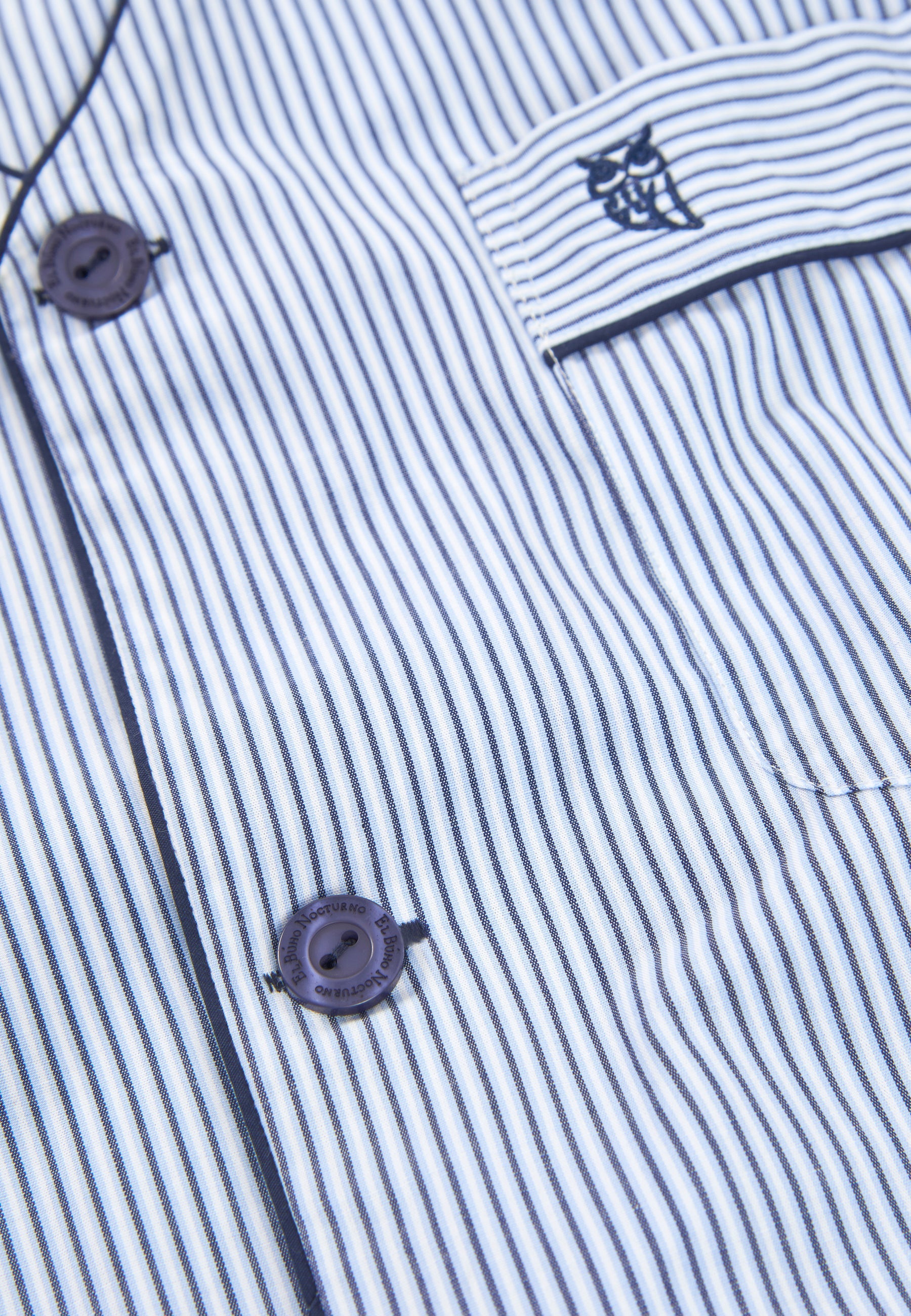 Camisa de algodón azul y blanca con rayas, botones oscuros y bolsillo con logo bordado. Ideal para un estilo casual.