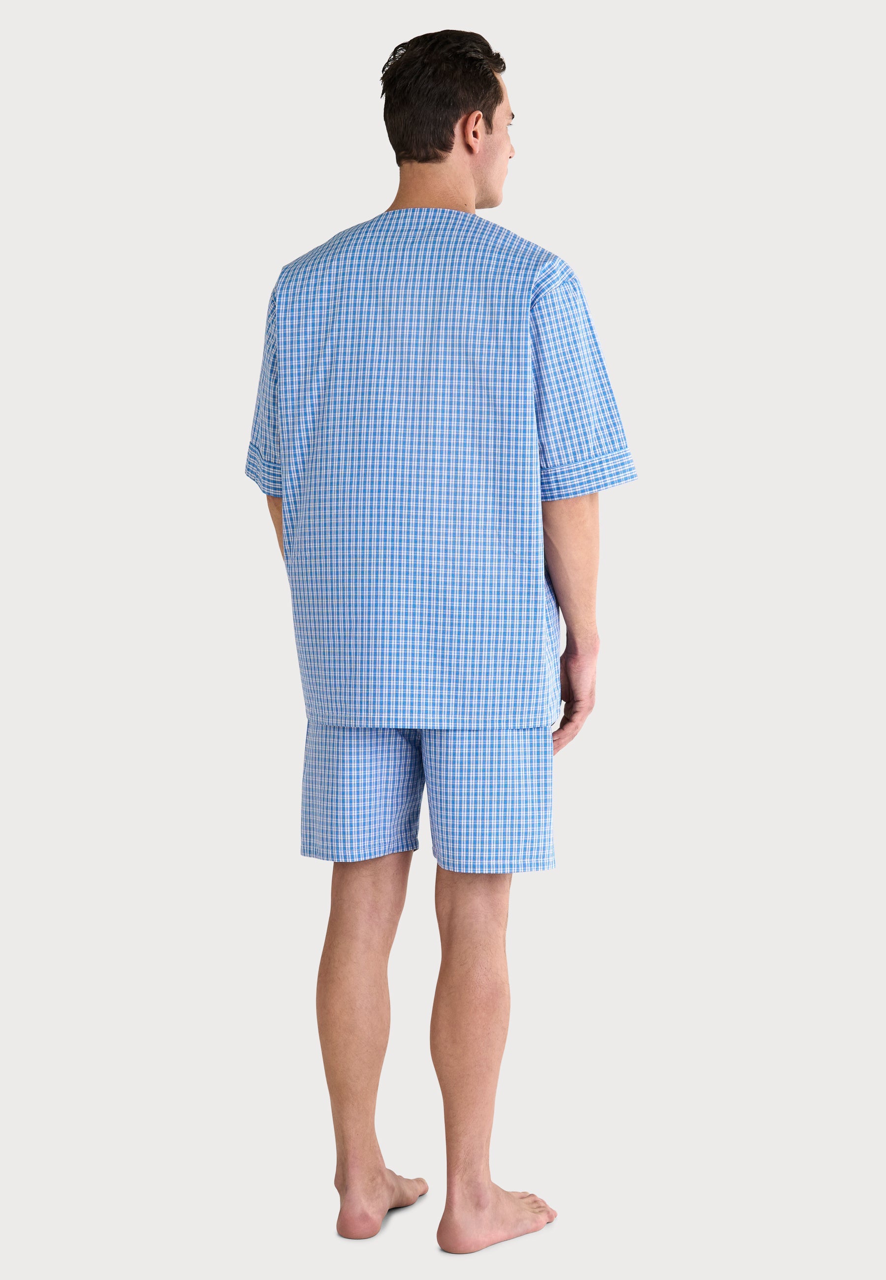 Pijama de hombre de cuadros en azul, corto y de algodón, con camiseta de manga corta y pantalones cortos.