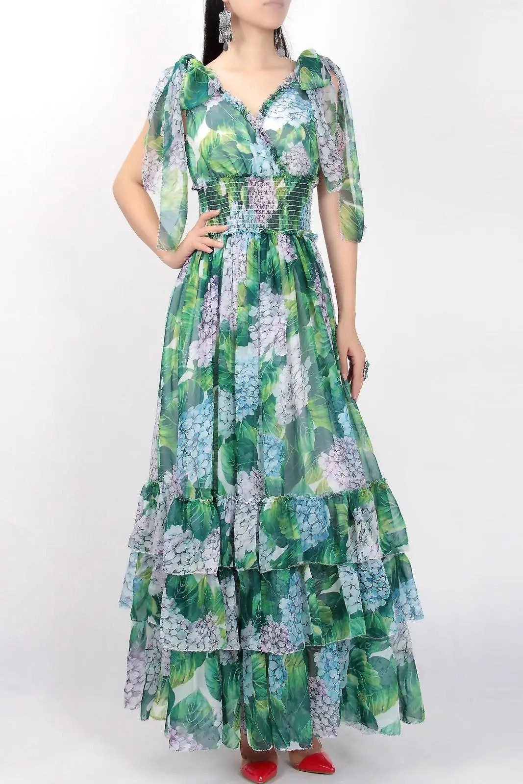 Blue and green floral maxi dress with tiered ruffles and sheer sleeves, perfect for summer occasions.