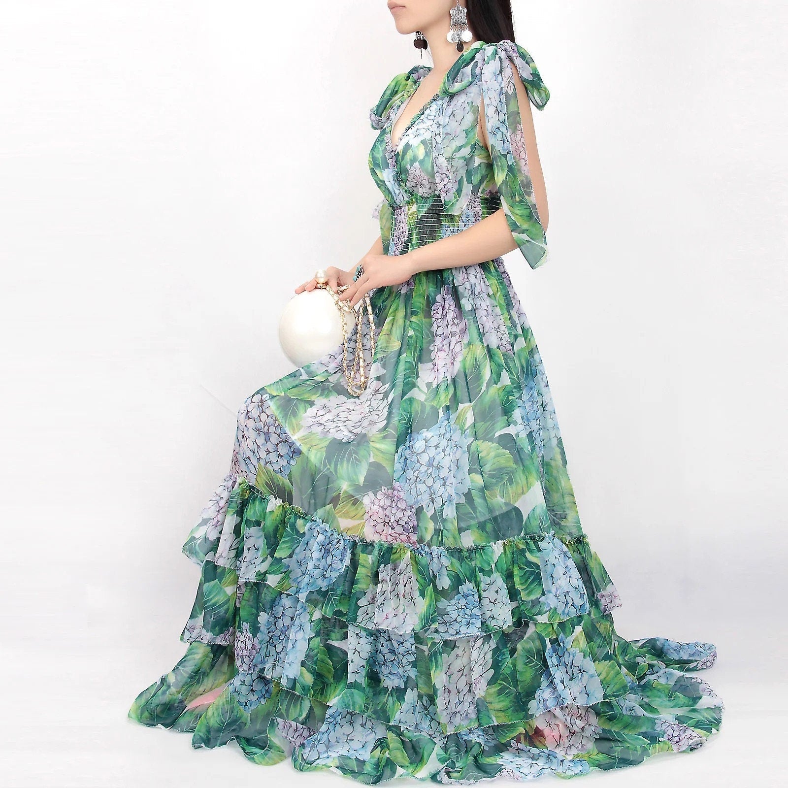 Floral maxi dress in green and blue chiffon, featuring ruffled sleeves and tiered hem for an elegant summer look.