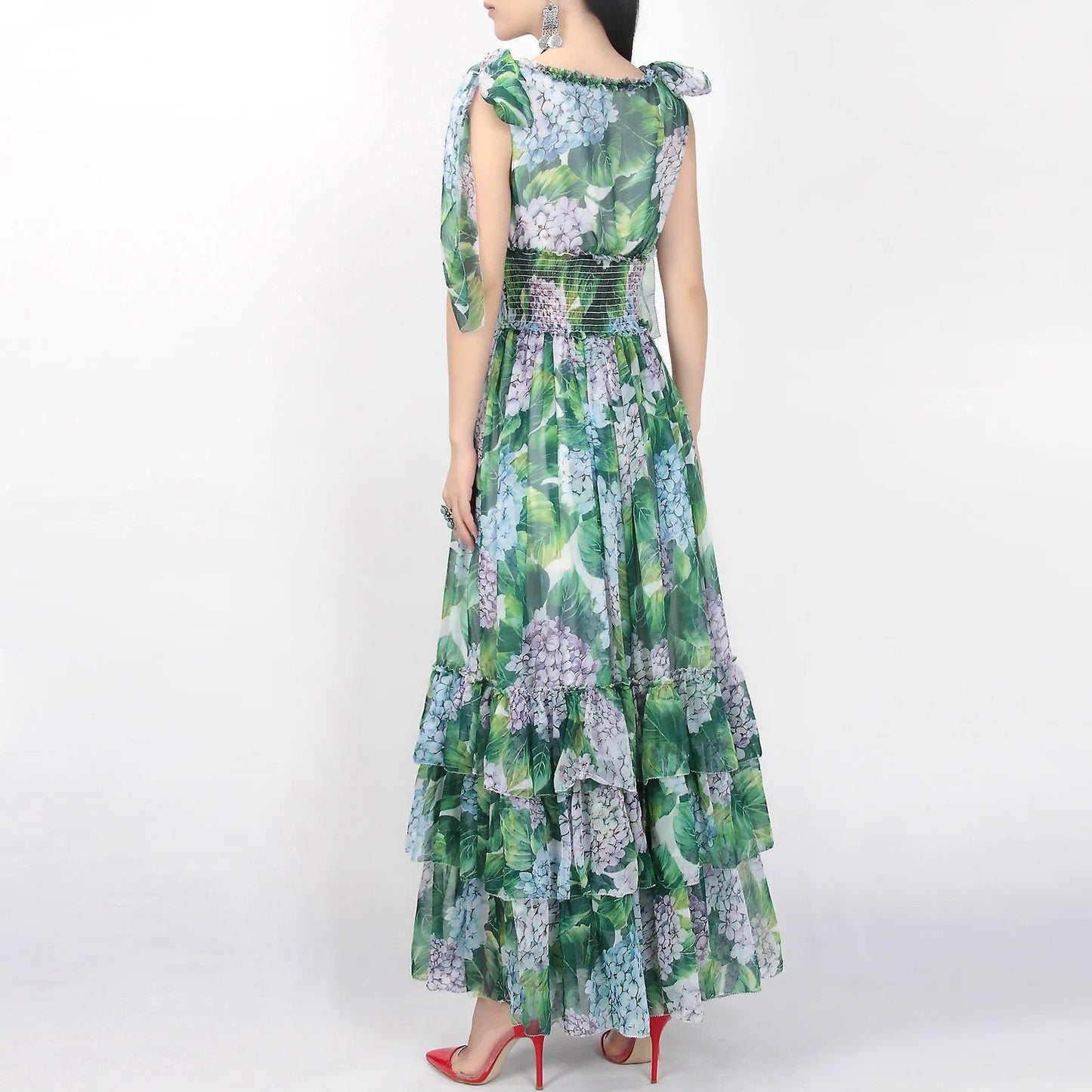 Floral maxi dress in green and blue with ruffled layers and bow sleeves, perfect for summer events.