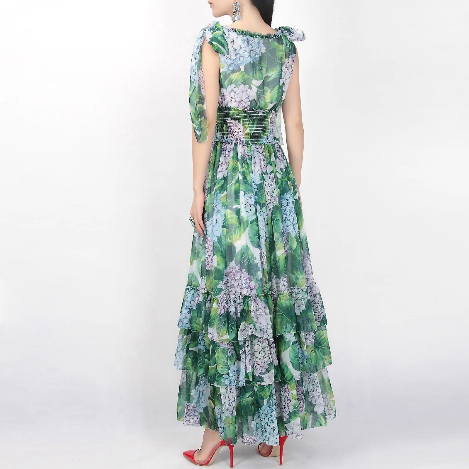 Floral maxi dress in green and blue with ruffled layers and bow sleeves, perfect for summer events.