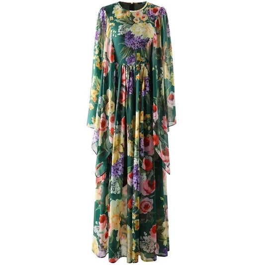 Floral maxi dress in green with purple, pink, and yellow flowers; long sleeves and flowing silhouette.