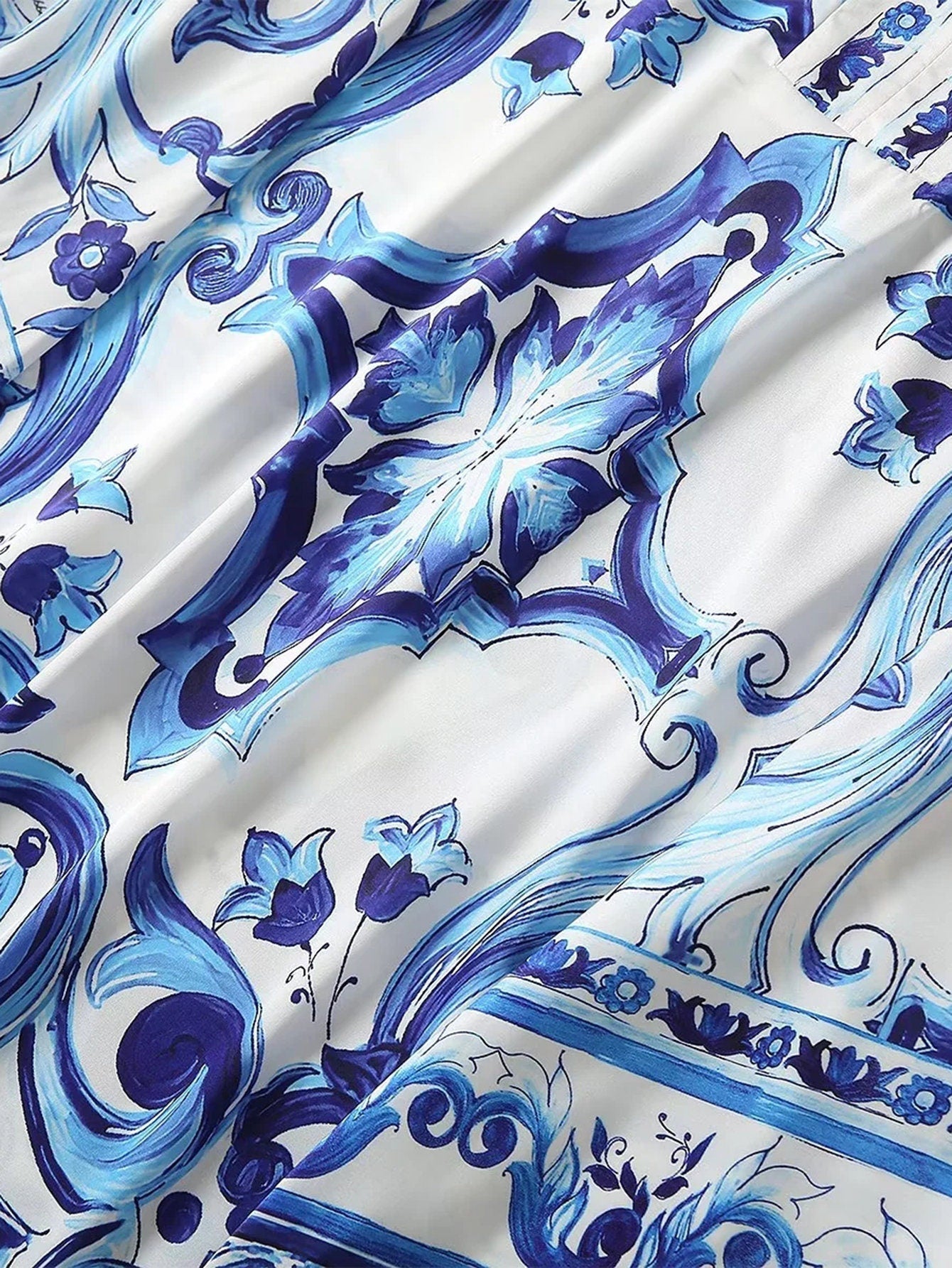 Elegant blue and white floral print fabric, featuring intricate designs on smooth silk material. Perfect for stylish garments.