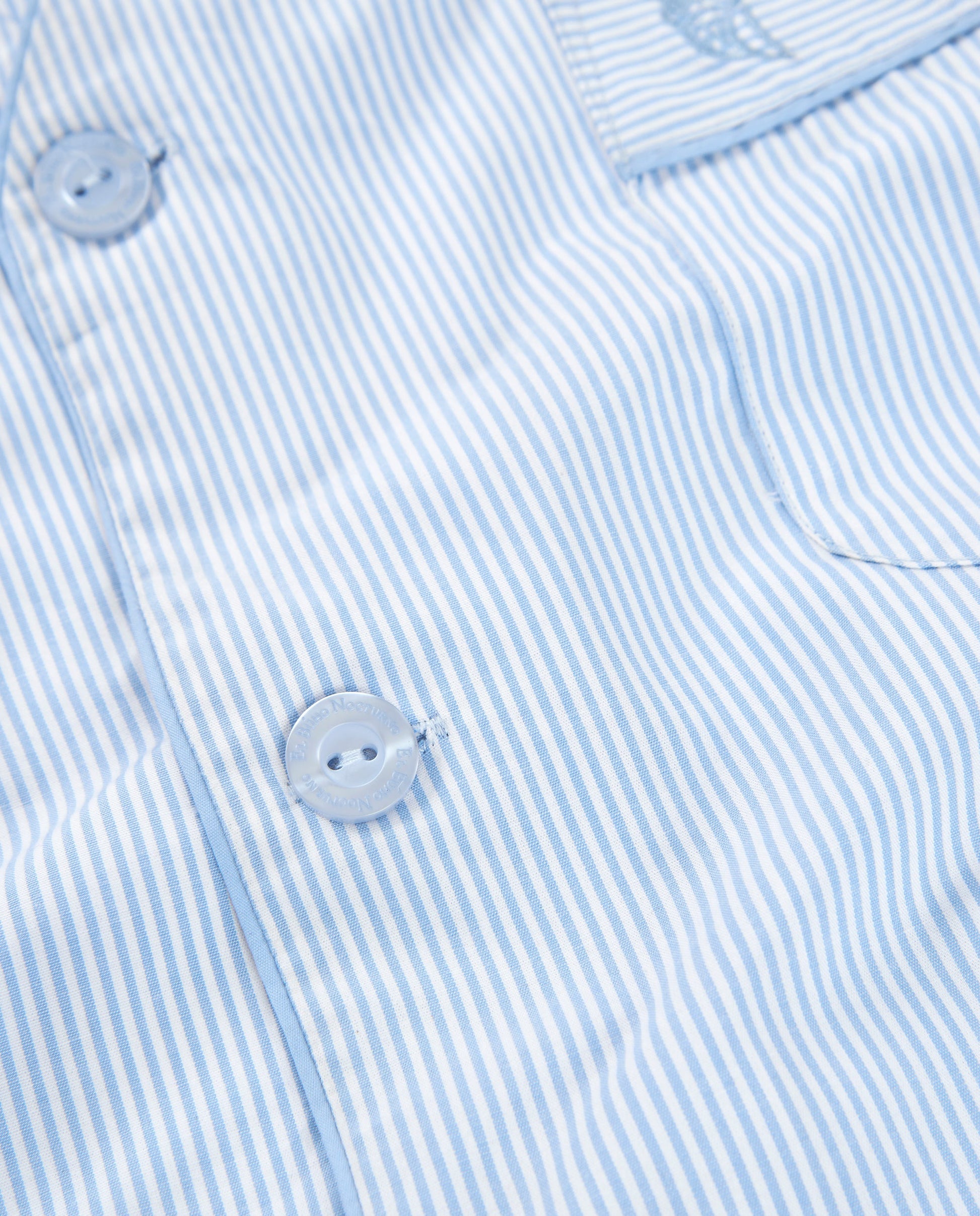 Camisa de rayas azul claro y blanco, algodón suave, estilo casual con botones transparentes.