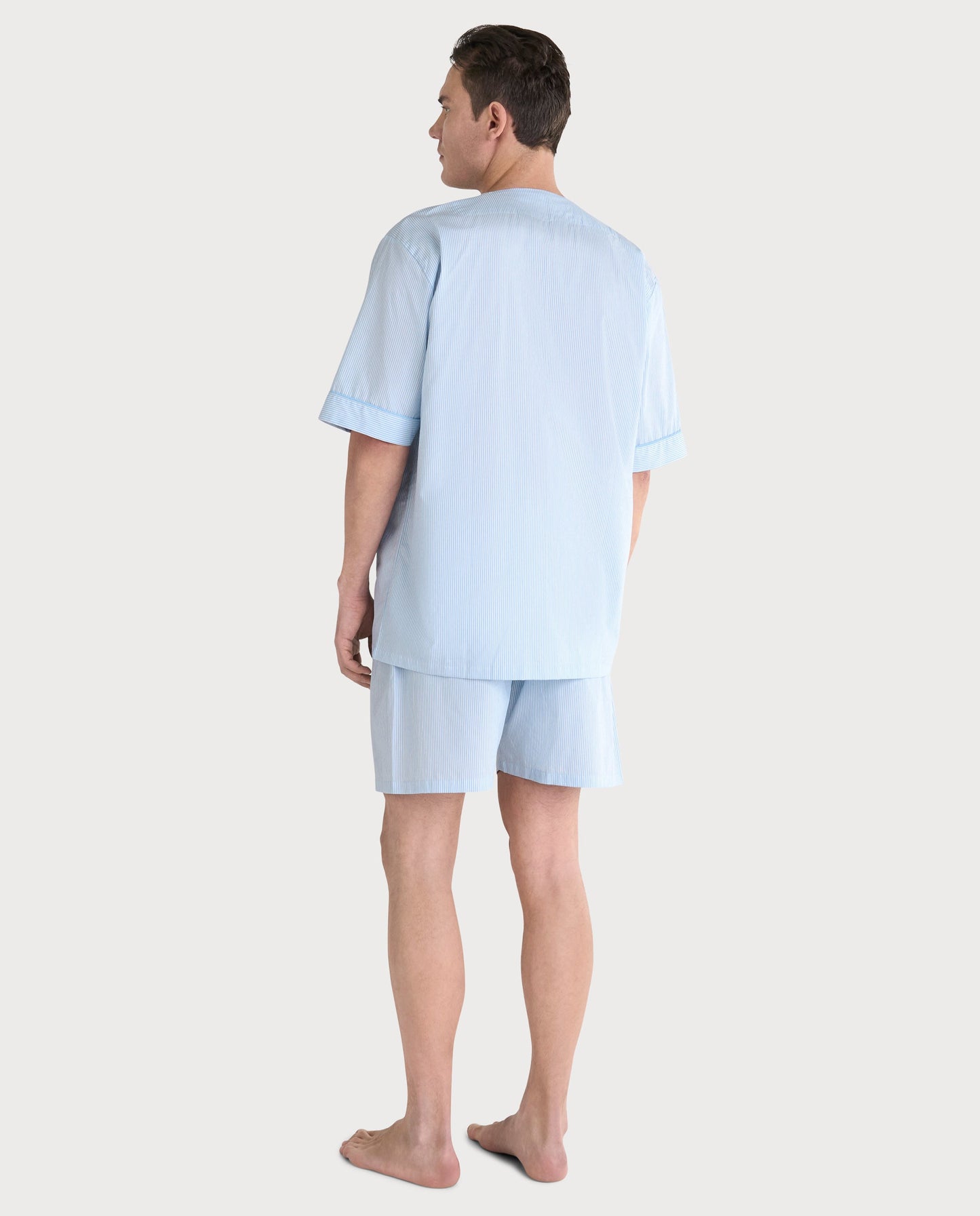 Pijama de hombre azul claro, de rayas, de algodón, con camisa de manga corta y pantalones cortos. Ideal para descansar.