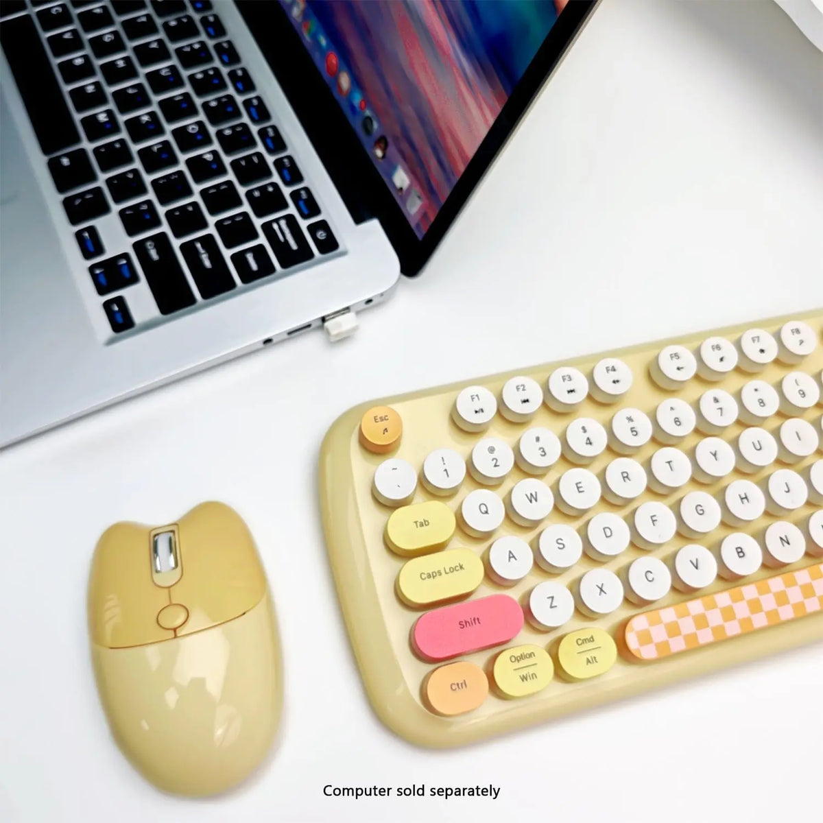 Yellow and white wireless keyboard with round typewriter-style keys, matching yellow mouse, on a white desk by a laptop.