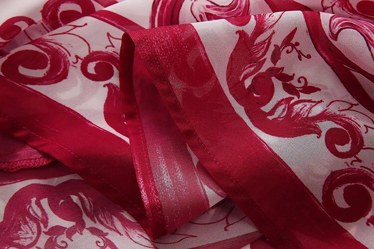 Red and white sheer fabric scarf with intricate floral pattern and elegant finish. Ideal for stylish layering.