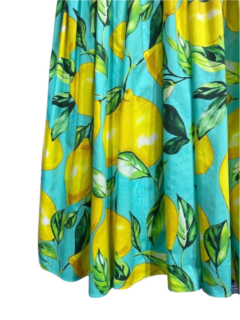 Bright lemon-print skirt in turquoise fabric, featuring vibrant yellow lemons and green leaves for a fresh summer look.