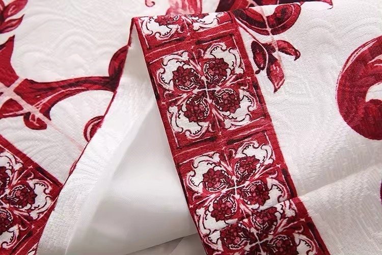 Red and white floral patterned cotton fabric with intricate detailing for home decor and crafting projects.