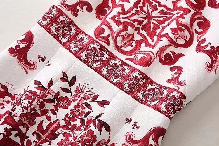 Red and white floral print fabric featuring intricate designs, perfect for crafting or home decor projects.
