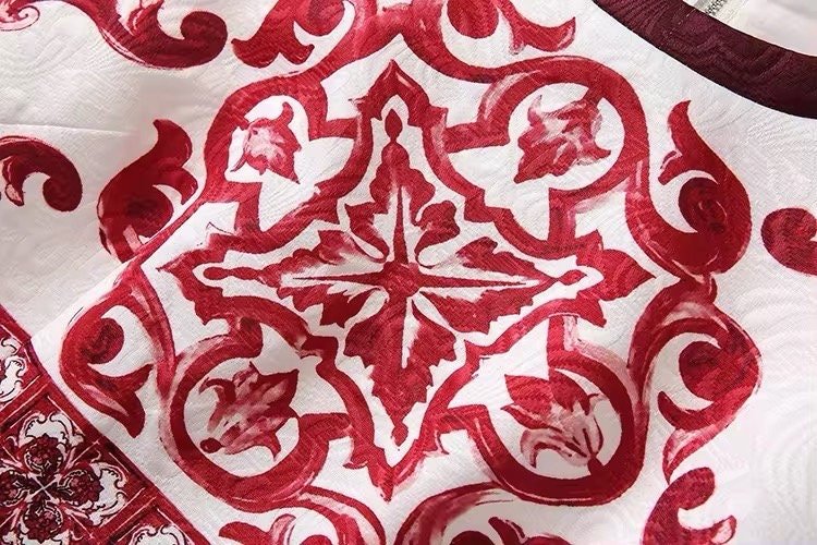 Red and white patterned fabric with intricate floral designs, perfect for elegant home decor or fashion projects.