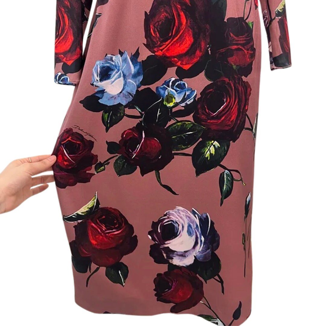 Floral print dress featuring deep red and blue roses on a soft pink background, perfect for casual outings.