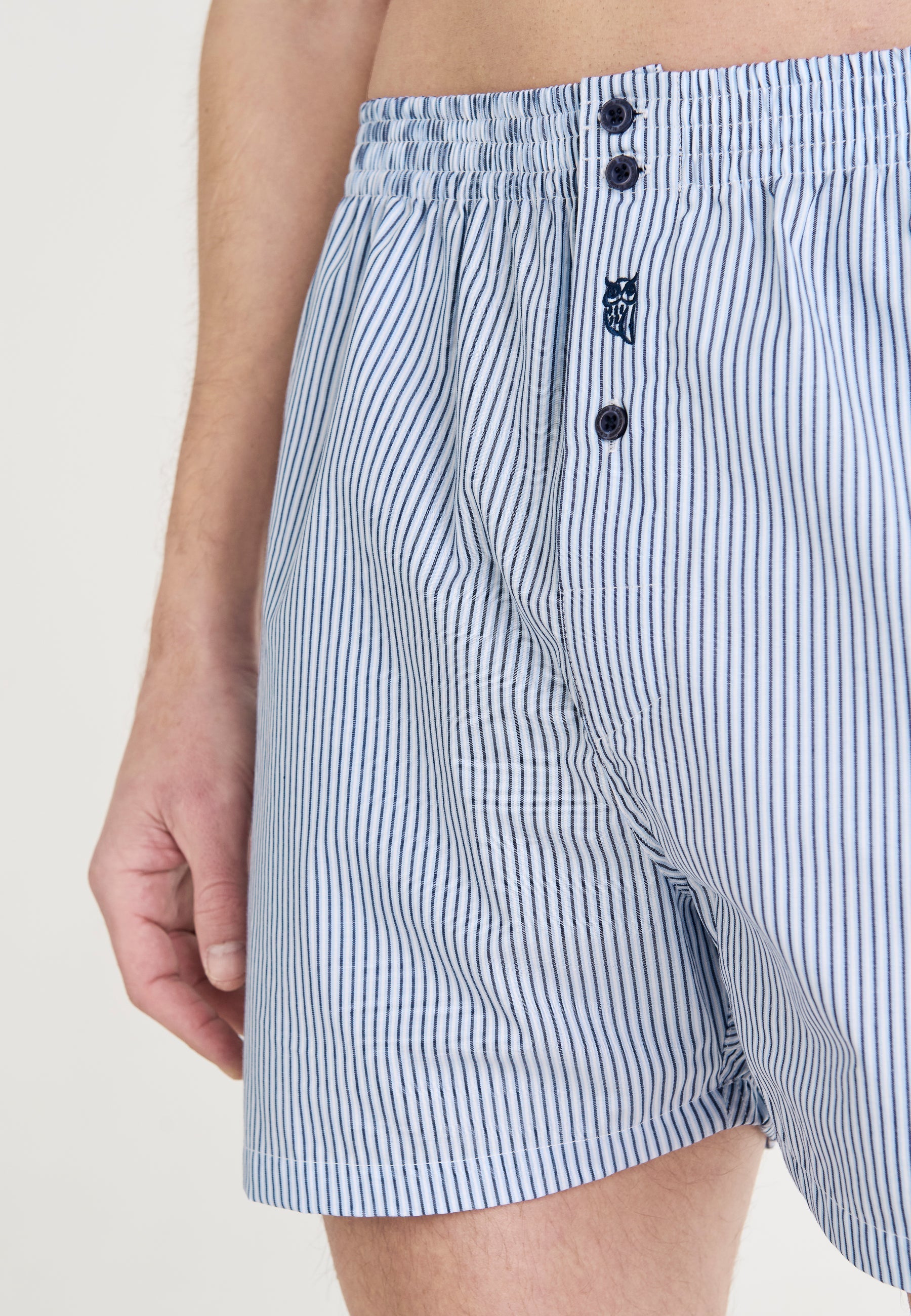 Pantalones cortos de hombre azul claro a rayas, de algodón, estilo clásico con botones en la parte delantera.