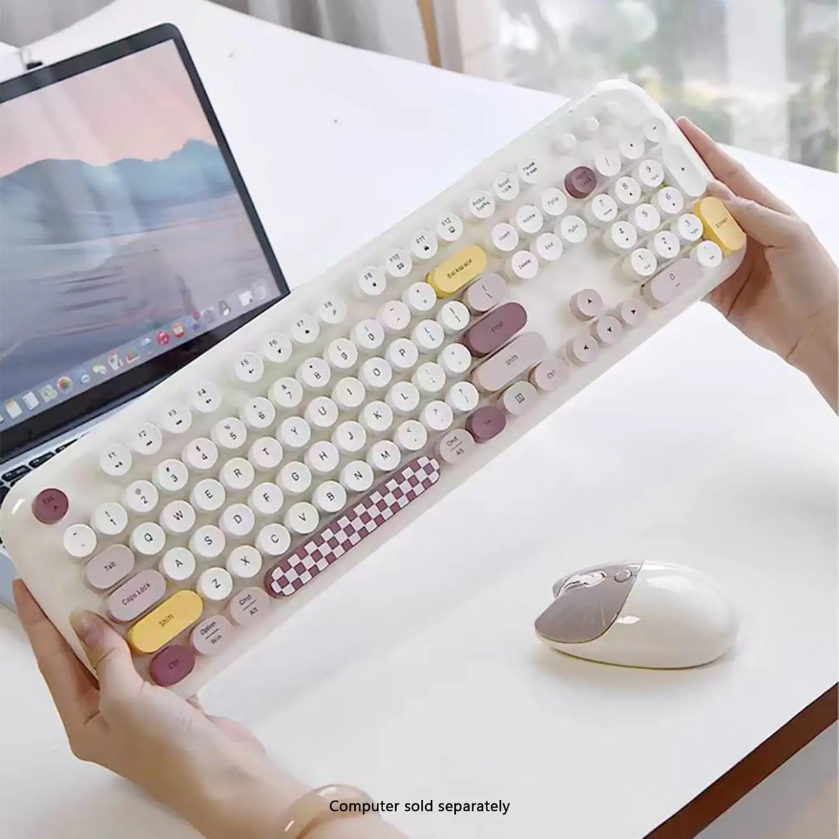Wireless keyboard and mouse set with round, multicolored keys, including a checkerboard spacebar, on a white desk.