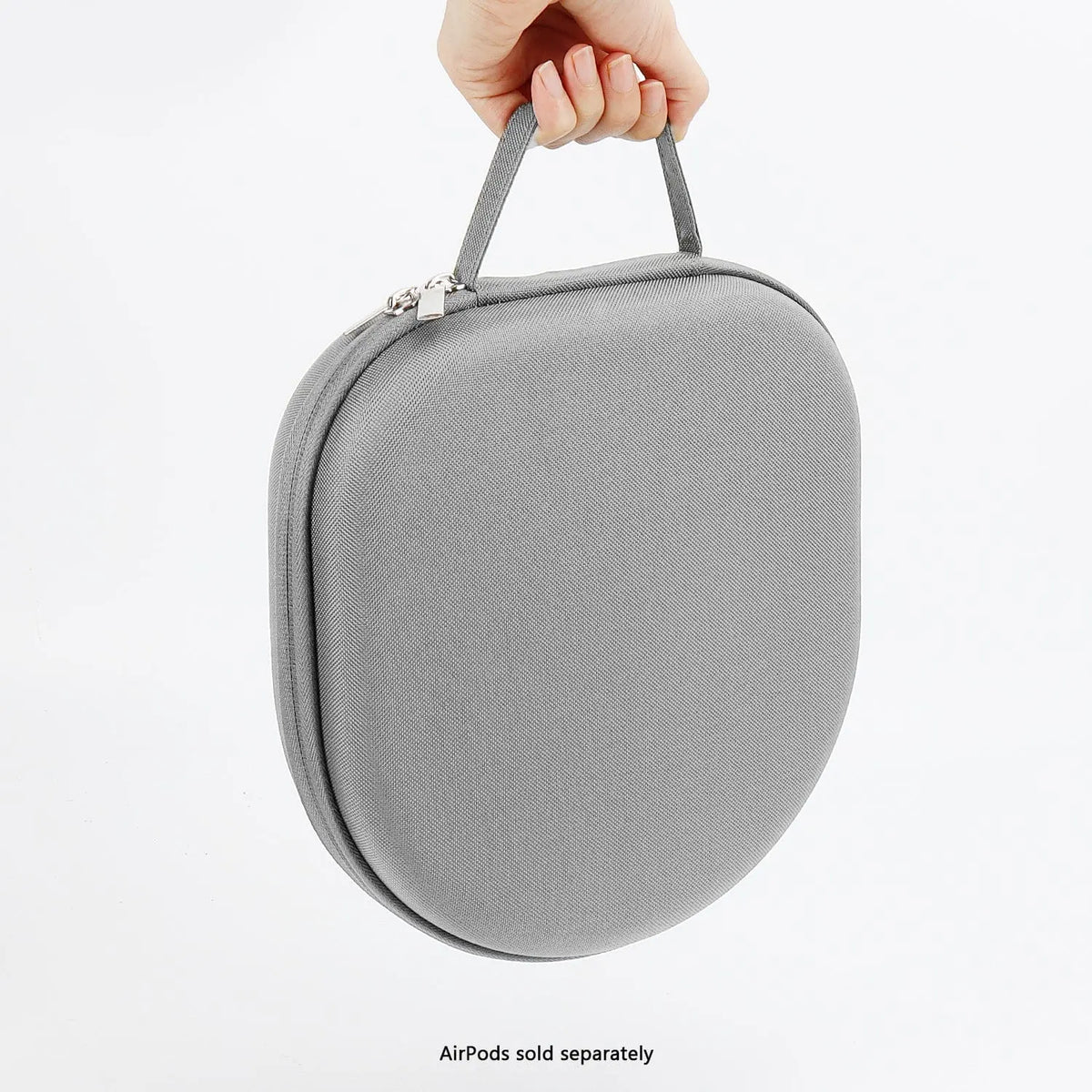 A hand holds a gray, hard-shell, textured fabric carrying case with a top handle and silver metal zipper.