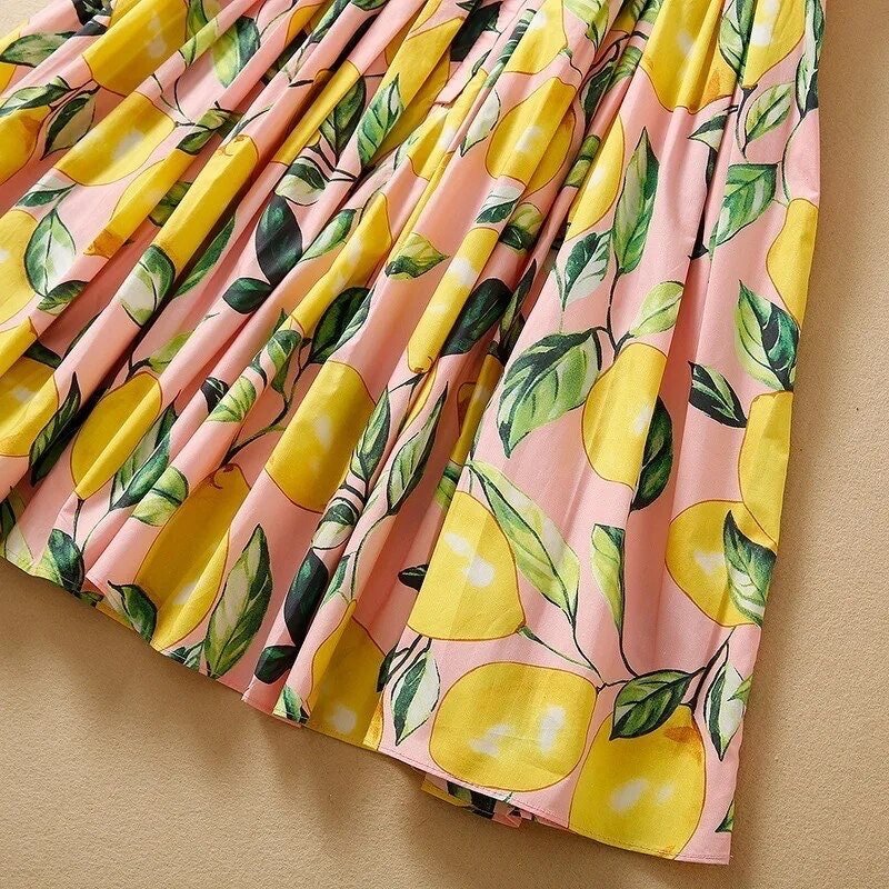 Pink lemon-print pleated skirt made of lightweight fabric, perfect for summer casual wear.