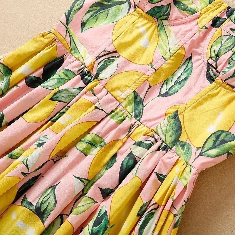 Pink lemon-patterned sundress with gathered waist and leafy accents, perfect for summer outings.