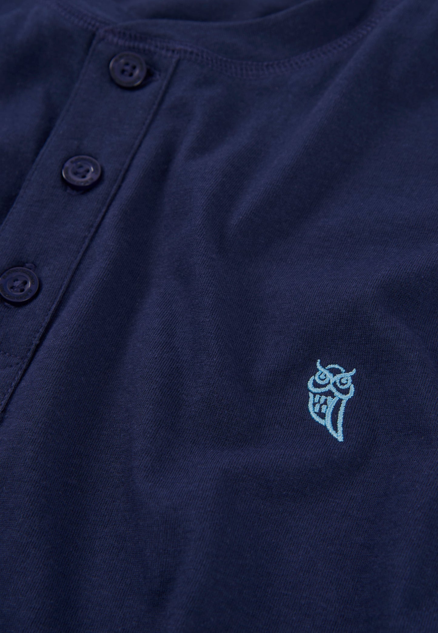 Camiseta de botones color navy con bordado de búho en tono aqua, de algodón suave y estilo casual.