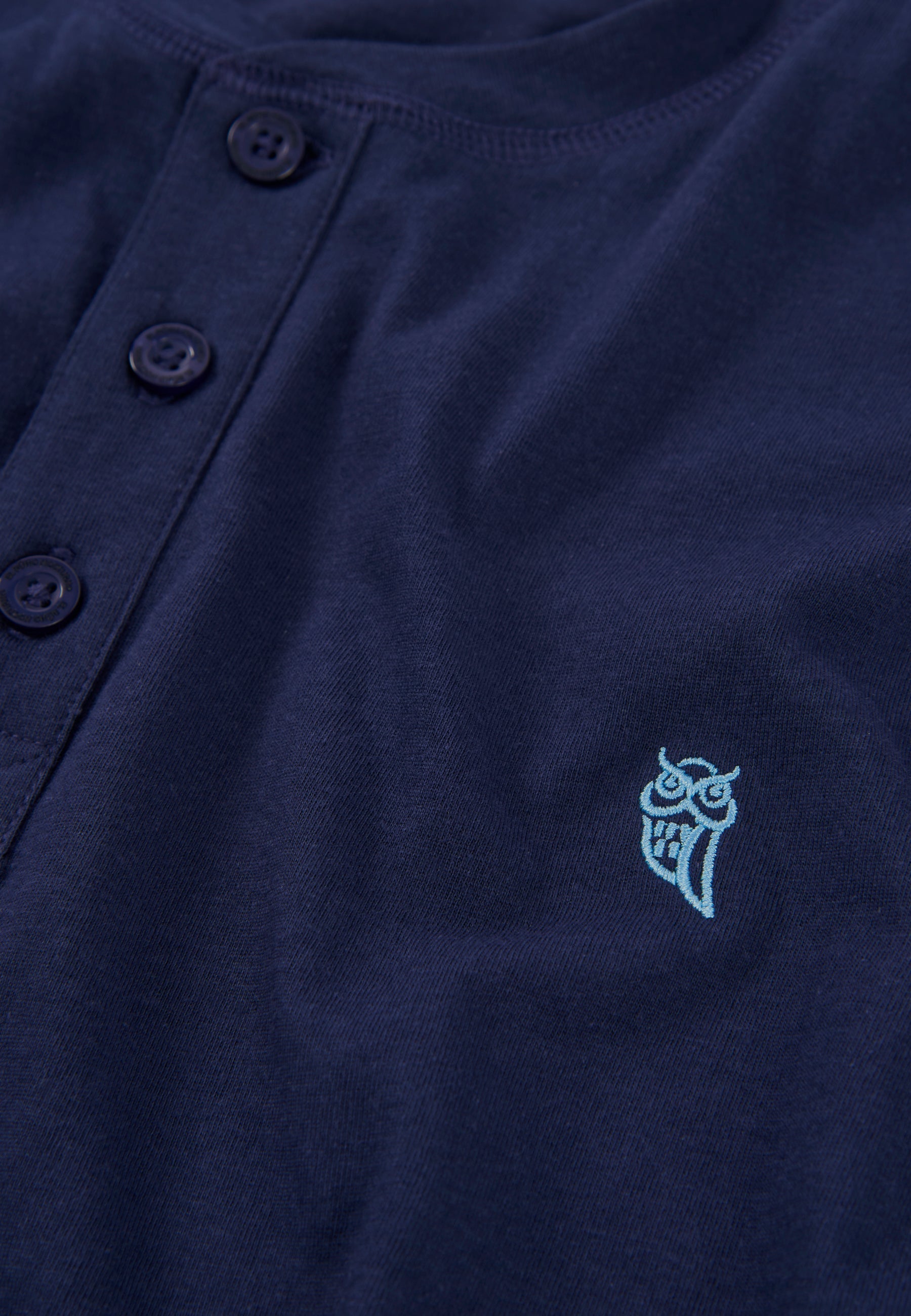 Camiseta de botones color navy con bordado de búho en tono aqua, de algodón suave y estilo casual.