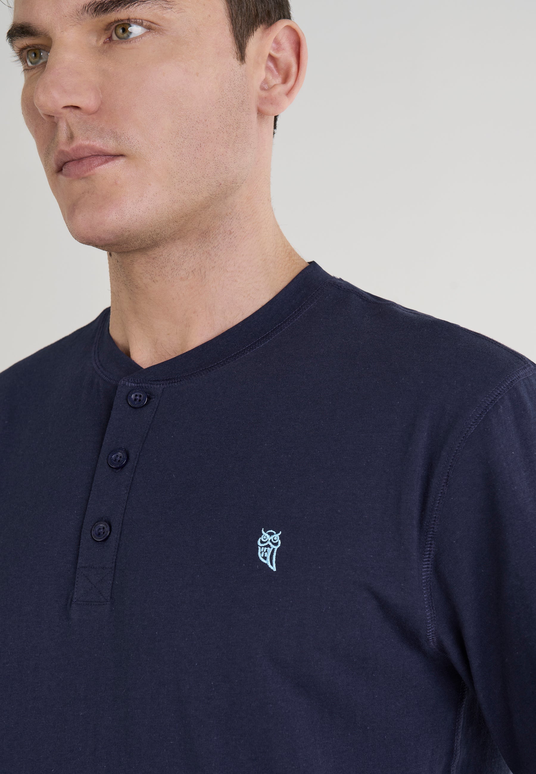 Camiseta masculina de algodón azul marino con botones y diseño bordado en el pecho. Estilo casual y moderno.