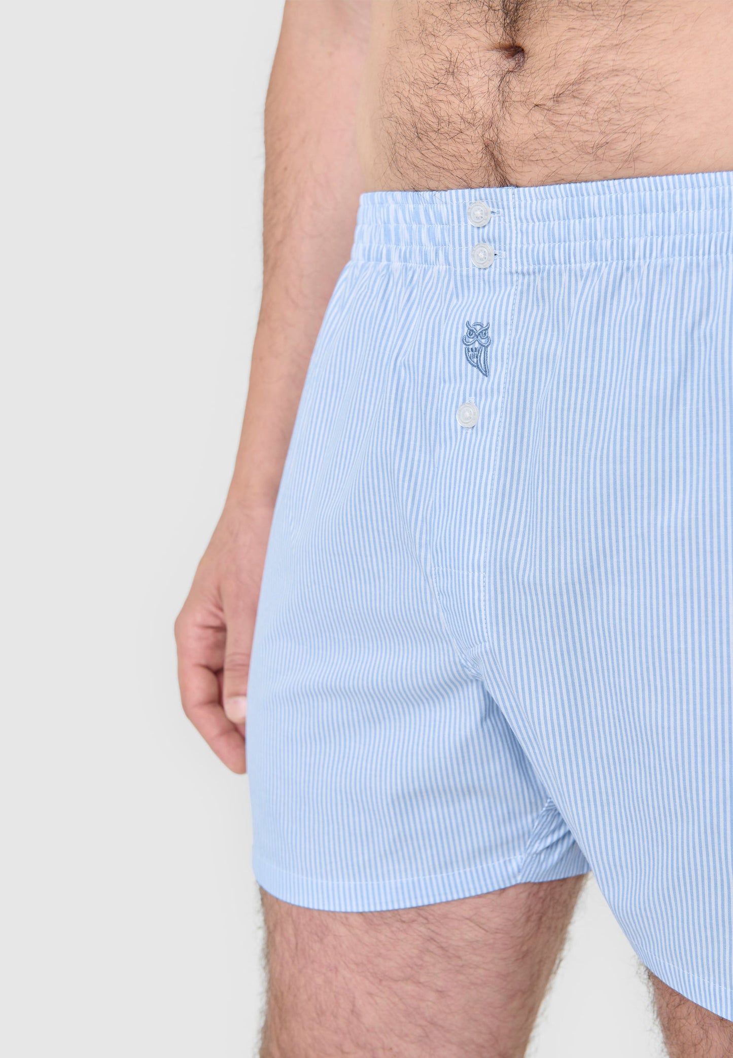 Boxer de hombre azul claro a rayas, fabricado en algodón suave, con diseño clásico y botón frontal.