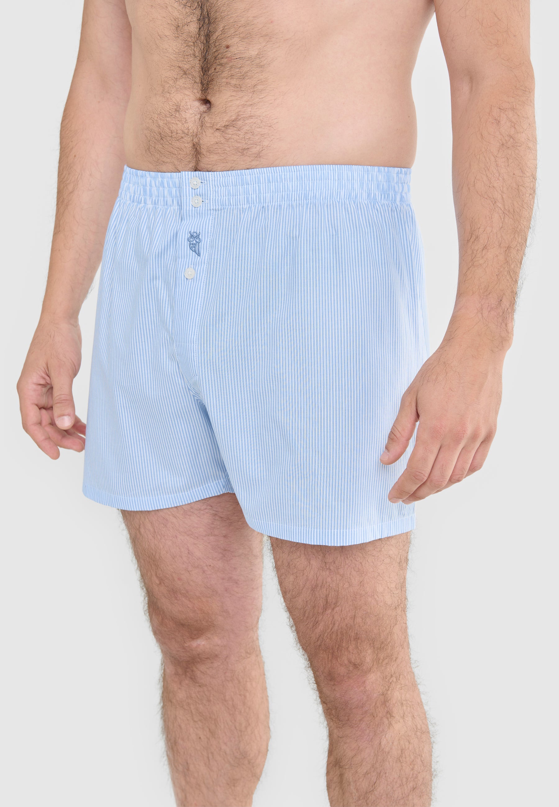 Boxers de hombre de algodón azul claro a rayas, cómodos y con cintura elástica y botones frontales.