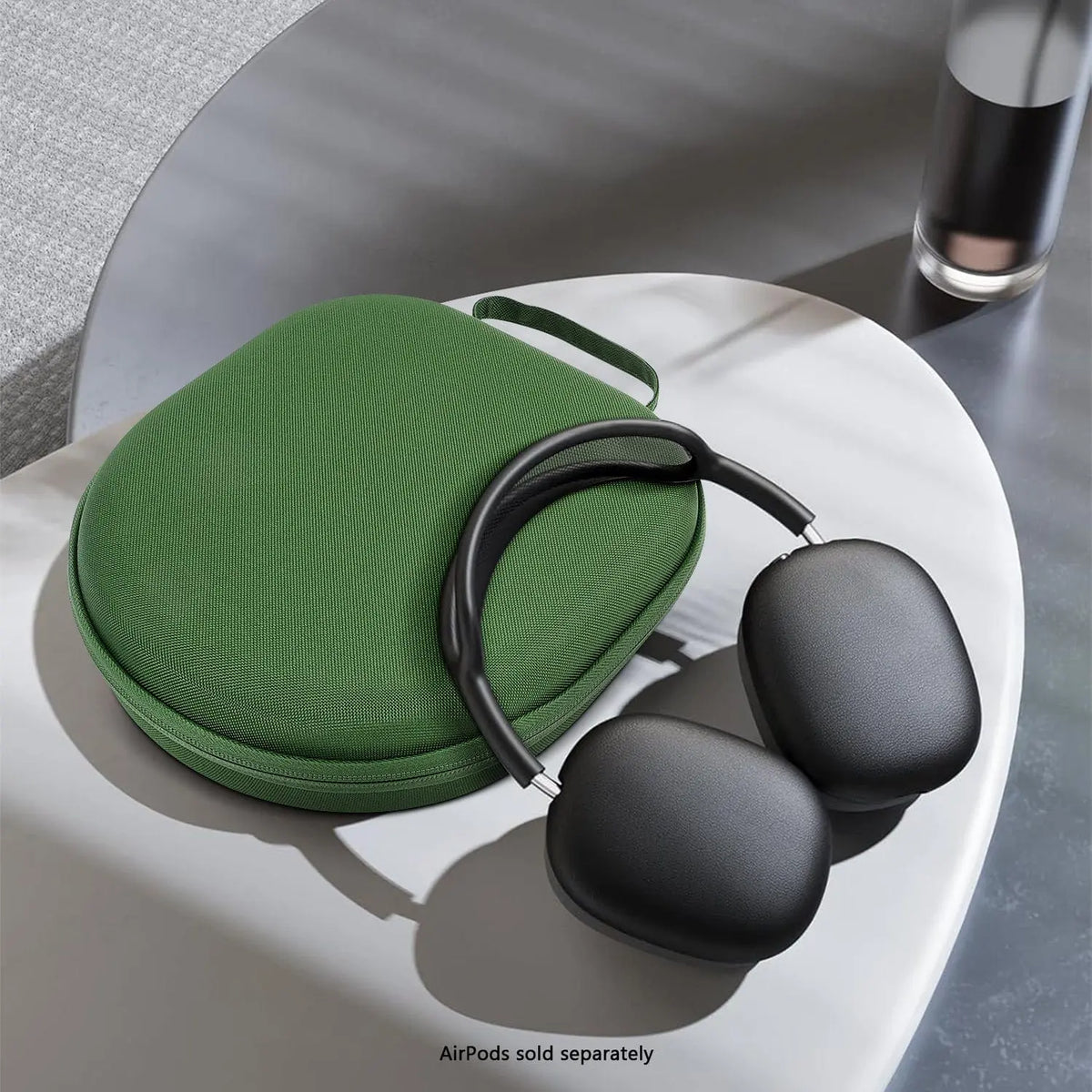 Green hard-shell fabric travel case for headphones, featuring a zip closure and wrist strap, with black headphones.