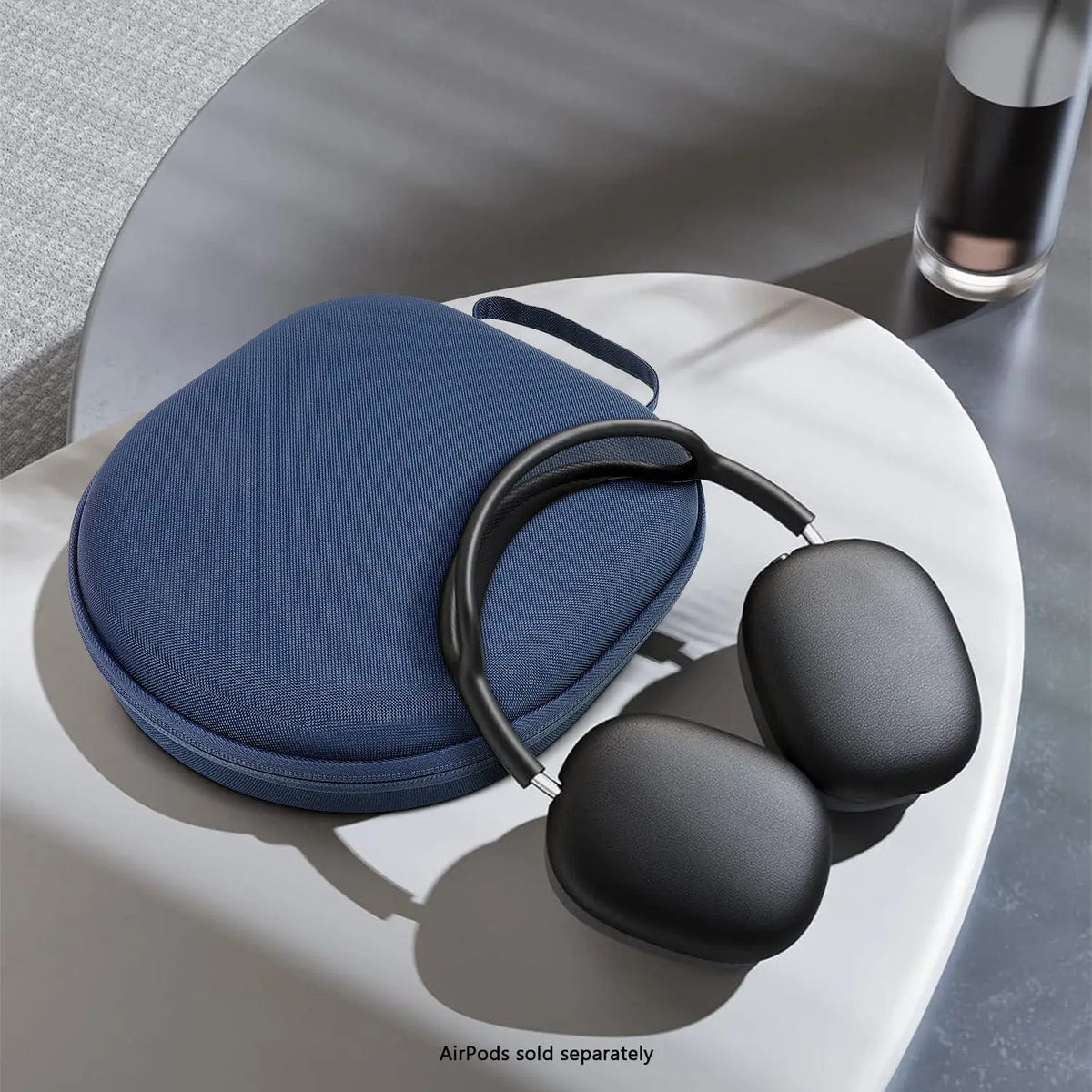 Navy blue fabric hard-shell travel case with zipper and carry strap, displayed next to black over-ear headphones.