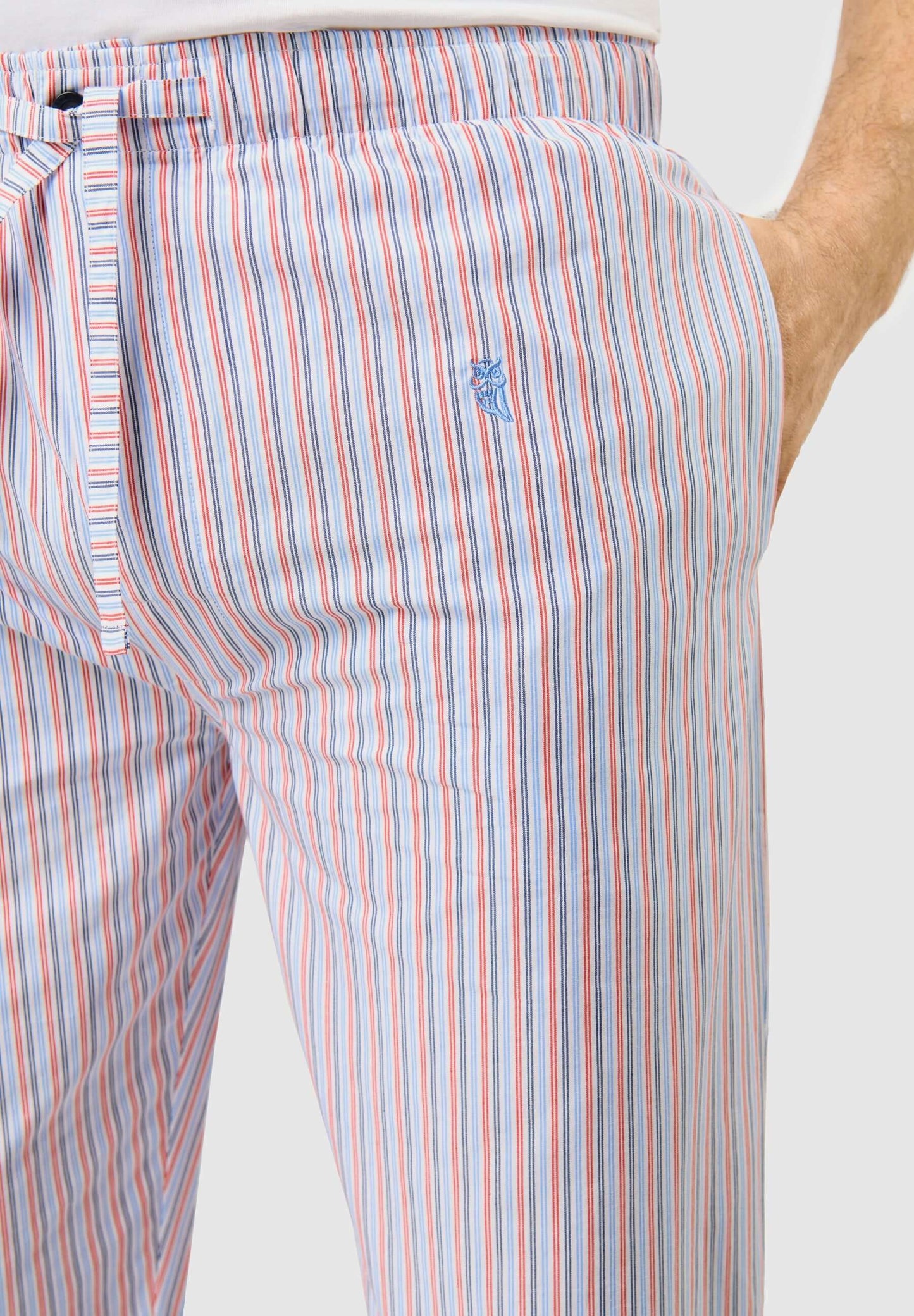 Pantalón Pijama Hombre largo de algodón popelín a rayas blancas y celestes, con logo bordado y perneras holgadas.