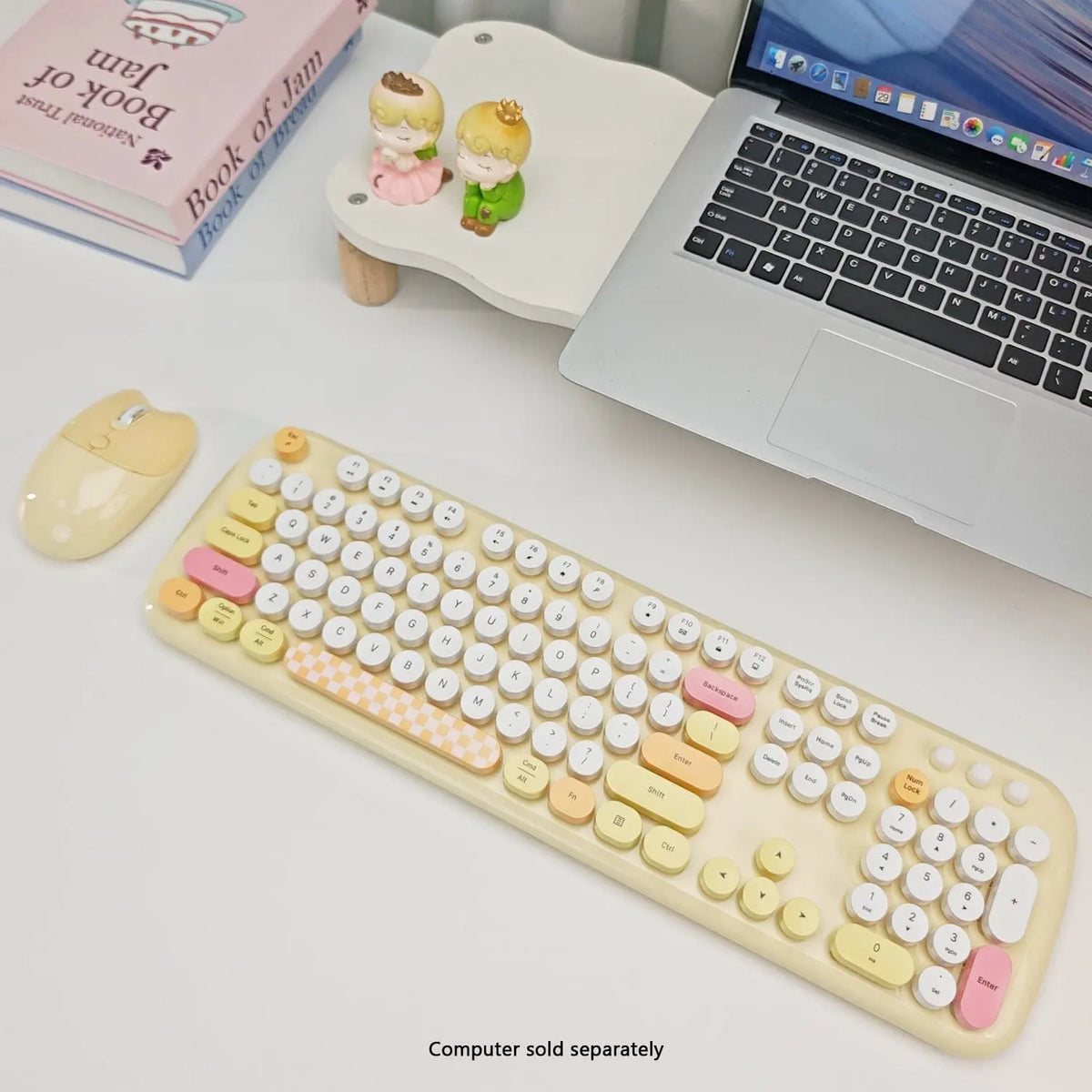 Pastel yellow wireless keyboard and mouse set with round keys, featuring pink and checkered accents on a white desk.