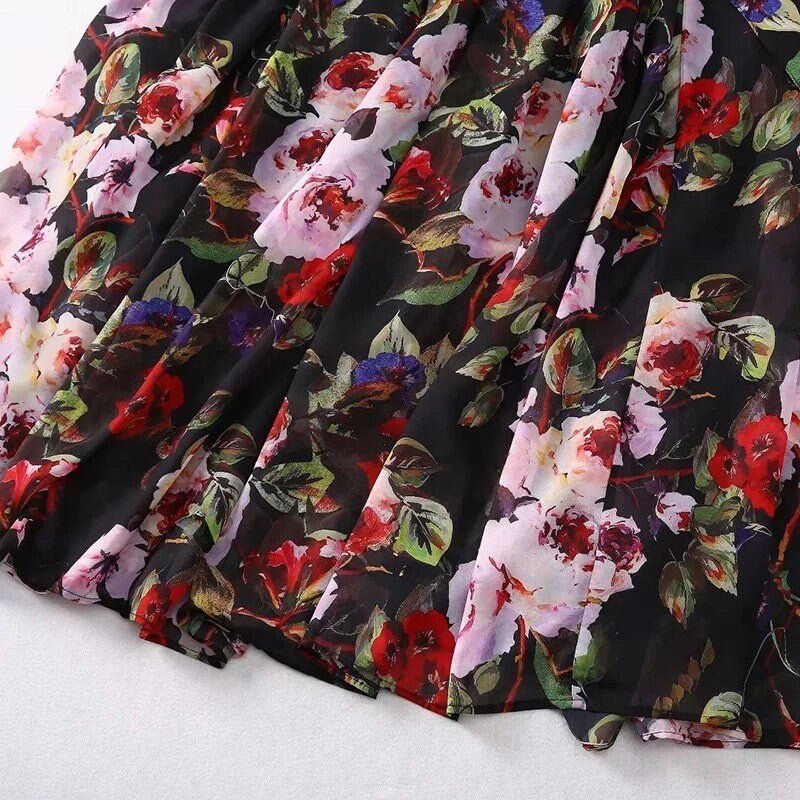 Black floral maxi dress with vibrant red and pink roses, crafted from lightweight chiffon fabric. Perfect for summer outings.