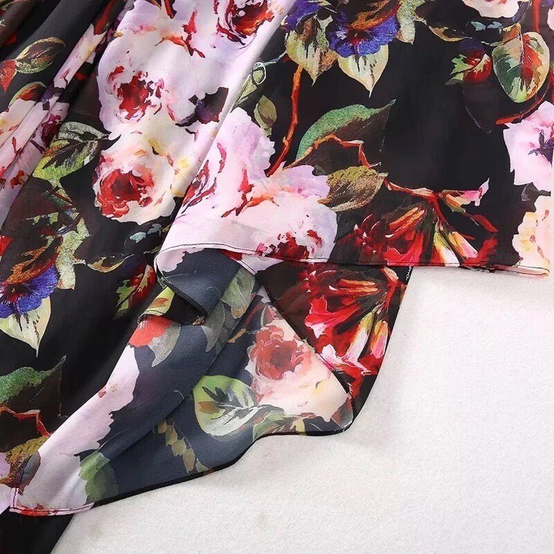 Black floral chiffon fabric with vibrant pink and red roses, perfect for dresses and lightweight garments.