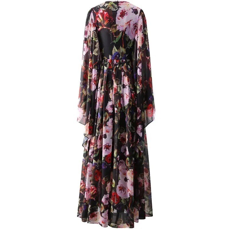 Flowy black floral maxi dress with long sleeves and an open back, featuring vibrant pink and red blooms on sheer fabric.