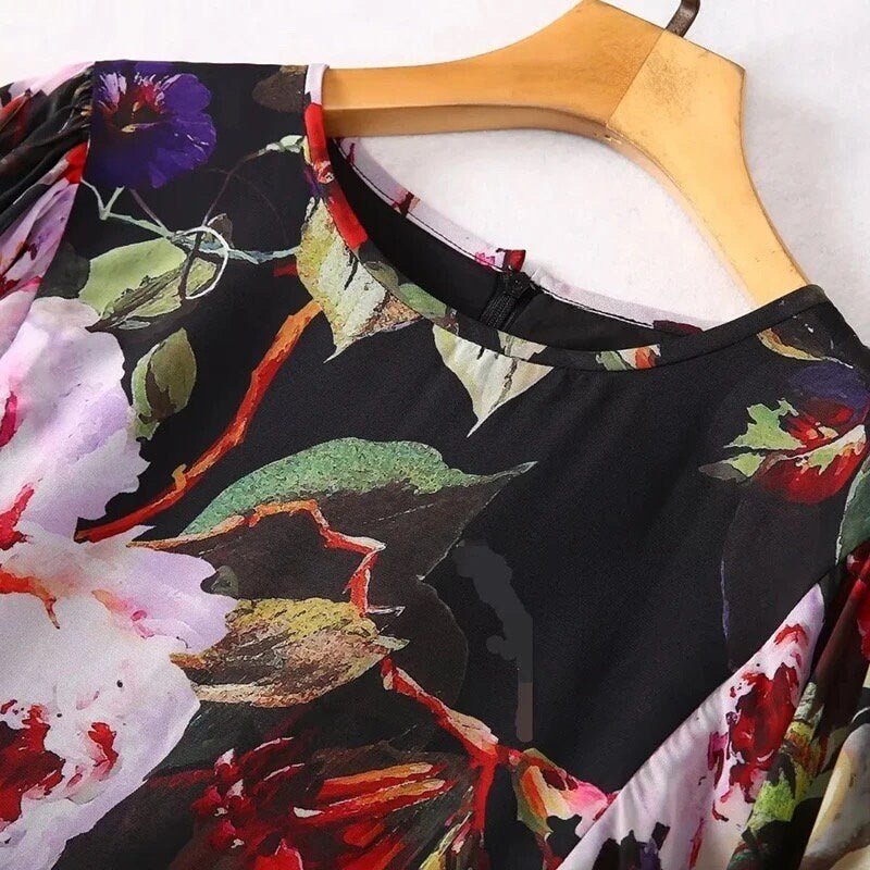 Black floral blouse with vibrant red and purple flowers, featuring a round neck and soft fabric, perfect for casual wear.